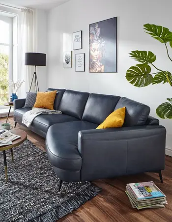 Dunkelblaue Ledercouch mit filigranen schwarzen Füßen.