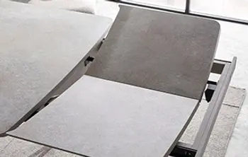 Detailansicht eines ausziehbaren Esstisches mit integrierter Einlegeplatte in Betonoptik – praktische Erweiterungsfunktion für zusätzlichen Platz beim Essen.