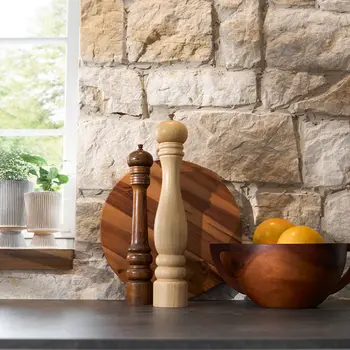 Deko auf einer schwarzen Küchenarbeitsplatte vor einer Ziegelwand eines Bauernhauses.