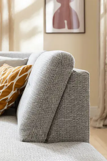 Seitliche Aufnahme der Rückenlehne eines grauen Ecksofas.