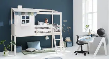 Ein Junge sitzt auf dem oberen Bett eines Etagenbetts in einem Zimmer mit Inneneinrichtung und Möbeln.