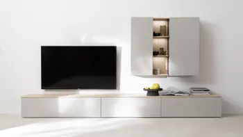 Hellgraue Designwohnwand bestehend aus Lowboard mit Holzabdeckung und einem Hängeregal mit beleuchteten Regalböden.