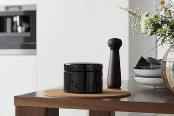 Tisch mit Deko und Resopalküche im Hintergrund