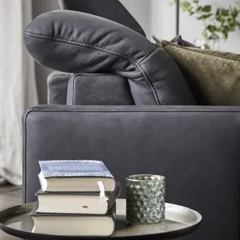 Seitenansicht eines grauen Sofas, bei dem die Kopfstütze nach hinten geklappt ist.