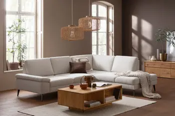 Beiges Ecksofa mit einem rechteckigen Couchtisch aus Holz.