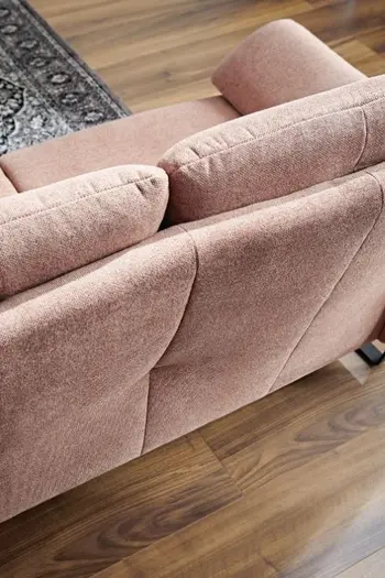 Rückansicht eines rosanen Sofas mit hohen Rückenkissen.