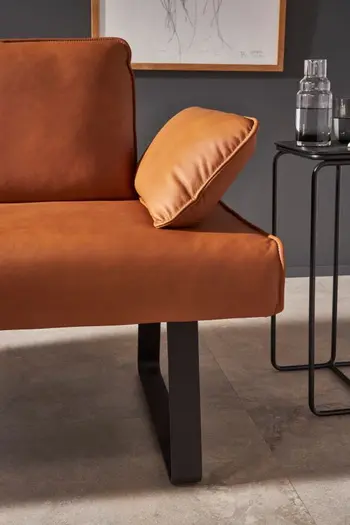 Cognacfarbene Sitzbank mit geklappter Armlehne.