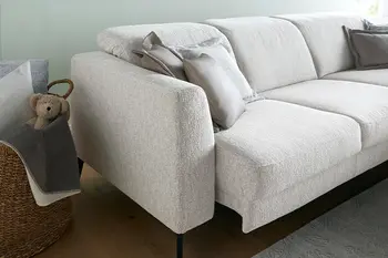 Detailbild von hellgrauem Stoffsofa mit motorischem Sitzvorzug.