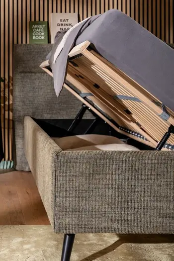 Ein dunkel graues Polsterbett mit geöffneten Bettkasten