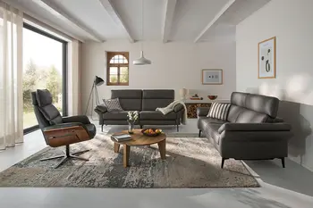 Minimalistisches Wohnzimmer mit zwei schwarzen Ledersofas und passendem Relaxsessel.