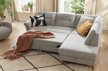 Graues Ecksofa mit ausgezogener Sitzfläche.