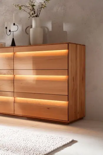 Hälfte eines Sideboards mit Schubladen, bei dem die Schubladenfronten beleuchtet sind.