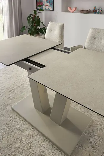 Auszugsystem von verlängerbarem Esstisch mit beiger Tischplatte.