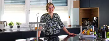 Frau Rösch in ihrer dunkelblauen Küche mit grifflosen Fronten