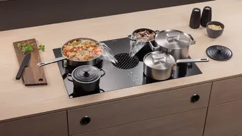 Kochfelder von BORA mit modernen Muldenlüftern, Töpfe und Pfannen mit Essen