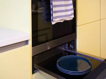 Tellerwärmer unter dem Backofen in gelber Küche