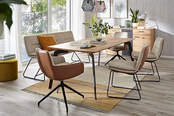 Moderne bequem gepolsterte Stühle mit und ohne Armlehne, die außen mit Leder in Cognac bezogen sind und innen mit weißem Stoff mit einer Sitzbank im gleichen Design um einen Massivholz Esstisch.