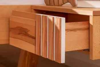 Nachttisch aus hellem Buchenholz mit geöffneter Schublade, die Front der Schublade hat rechts Lamellenakzente.