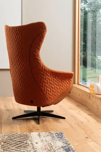 Rückansicht eines orangen Relaxsessels mit schwarzem Drehgestell.