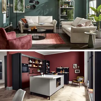 Cremefarbene Sofas in grünem Wohnzimmer und anthrazitfarbene Inselkueche.