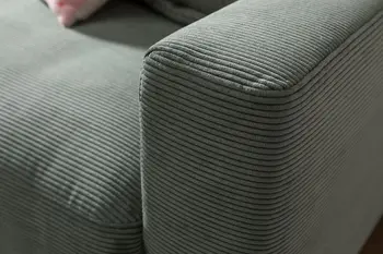Detailaufnahme einer Ecke eines grünen Cordsofas.