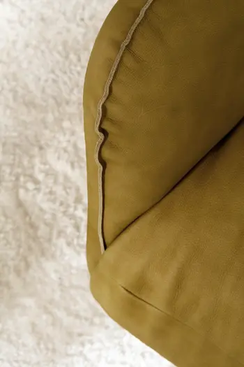 Armlehne und Sitzfläche eines gelben Ledersessel mit Relaxfunktion.