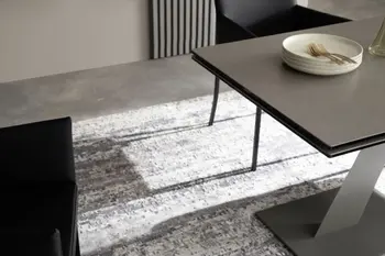 Moderner schwarzer Esstisch, bei dem man unter der Tischplatte eine ausziehbare Erweiterung sehen kann.