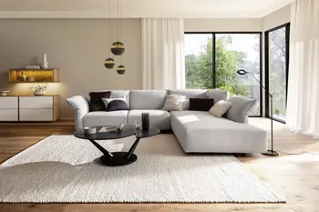 Moderner runder schwarzer Couchtisch mit Keramikoberfläche vor einem grauen Sofa.