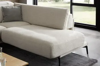 Beiges Sofa mit bequem gepolsterter Sitzfläche und silbernen Füßen.