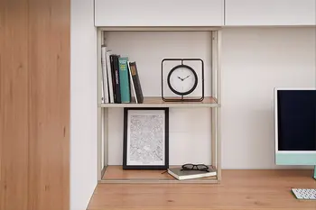 Regalsystem mit Büchern Uhr und Brille auf Arbeitsfläche