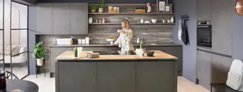 Frau genießt ein Getränk in eine Betonküche