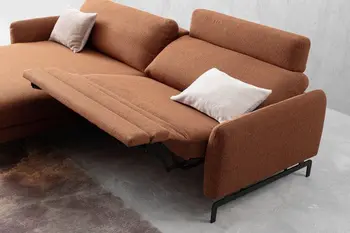 Rostrotes Ecksofa mit aufgestellter Kopfstütze und ausgezogener Fußstütze.