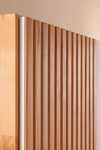 Nahaufnahme einer Türe eines Kleiderschrankes aus Buche mit Lamellenoptik.