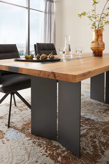 Design Esstisch mit Massivholz Tischplatte mit Epoxidharzfüllung und Wangengestell.