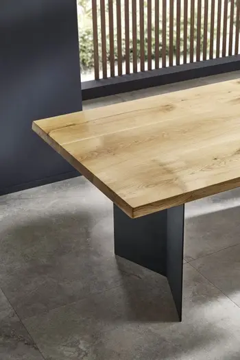 Massivholz Esstisch mit schwarzem dreieckigen Metallgestell.