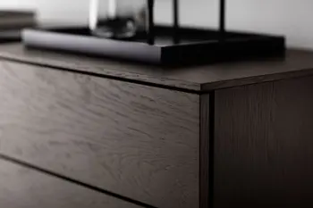 Teil einer modernen braunen Kommode, die Schubläden hat.