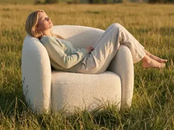 Eine Frau sitzt bei sommerlichen Temperaturen in einem Sessel