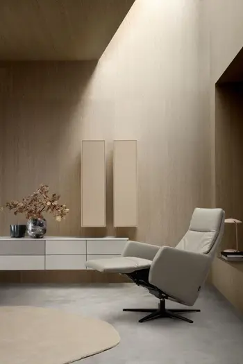 Beiger Relaxsessel in Relaxposition vor einer modernen Wohnwand in beige.