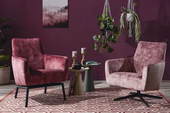 Zwei beerefarbene Sessel nebeneinander, der linke mit schwarzen Metallfüßen, der rechte mit schwarzem Drehgestell die vor einer beerefarbenen Wand stehen.