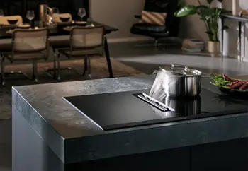 Kochfeld von Siemens auf einer Kochinsel. Auf dem Kochfeld steht ein dampfender Kochtop. Der Dampf wird von der integrierten Dunstabzugshaube des Kochfelds perfekt abgezogen.&nbsp;