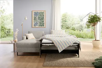 Ausgeklapptes Schlafsofa mit Kaltschaummatratze in modernem Wohnzimmer.