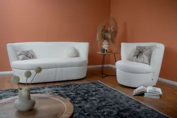 Modernes weißes rundes Sofa neben einem modernen weißen runden Sessel mit Boucle Bezug.