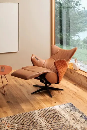 Oranger Relaxsessel, der innen mit Leder und außen mit Stoff bezogen ist in Liegeposition.