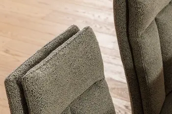 Oberer Teil der Rückenlehne eines gut gepolsterten Stuhls mit grünem Bouclé.