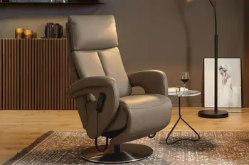 Grauer Relaxsessel mit hoher Rückenlehne in einem gemütlichen Raum mit Beleuchtung.