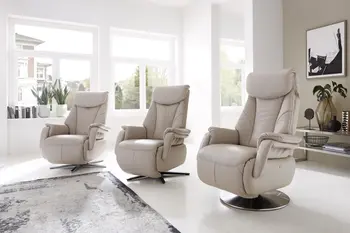 Drei cremefarbene Relaxsessel mit unterschiedlichen Fußgestellen in einem hellen Raum.