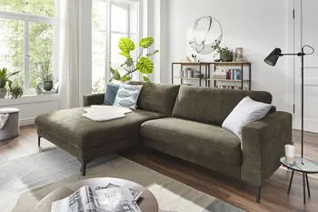 Olivgrünes Ecksofa mit breitem Longchair in einem hellen Raum.