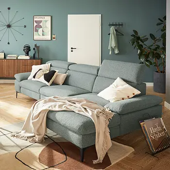 Türkisfarbenes Stoffsofa in einem gemütlichen Raum mit türkisfarbenen Wänden und Holzboden