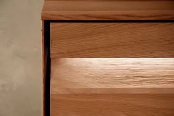 Beleuchtete Griffleiste einer Wohnwand aus Eiche.