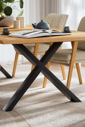 Pulverbeschichtetes, schwarzes Metallgestell in X-Form eines Esstisches.